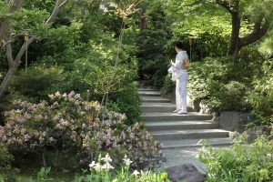 Femme en kimono montant des escaliers dans un jardin